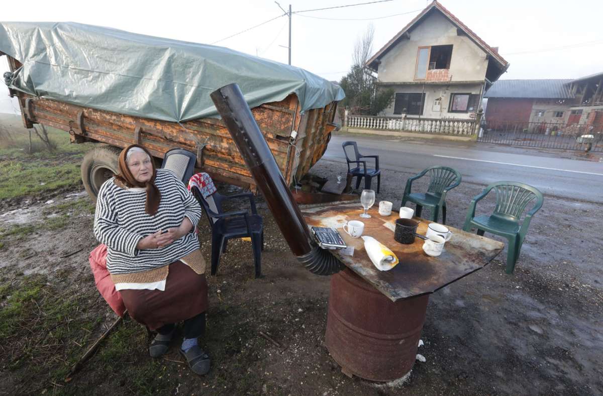Diese Frau hat in einem kroatischen Dorf aus Angst vor weiteren Erdbeben die Nacht im Freien verbracht und sitzt an einem Ofen.