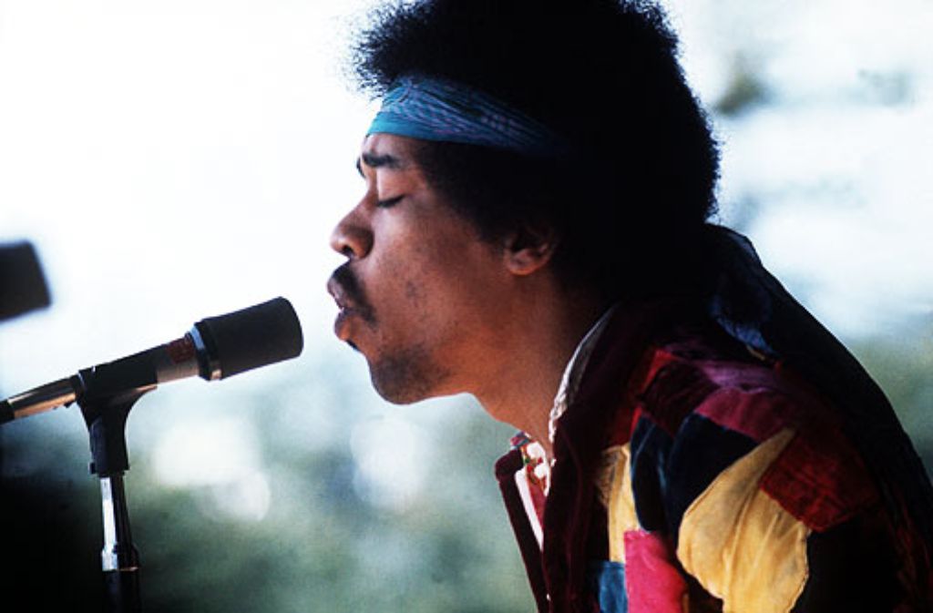 ... Jimi Hendrix mit der linken Hand in die Saiten.