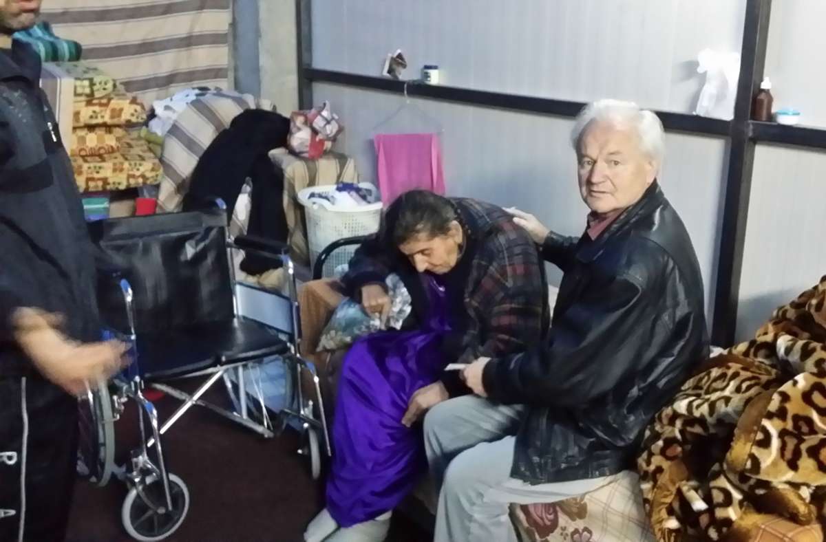 Werner Reutter übergibt einer alten Frau in einem Flüchtlingslager eine Geldspende