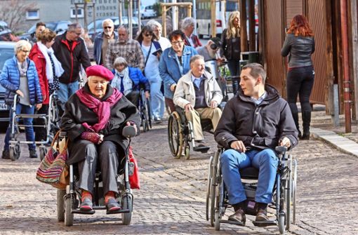 Rollstuhl-Rallye mit Daniel Töpfer: Der Bürgermeister und Gemeinderäte erkunden mit   Rollstuhlfahrern den Ortskern um Barrieren zu finden.   Ingrid Engel zeigt, wo Stolperfallen sind. Foto: factum/Bach