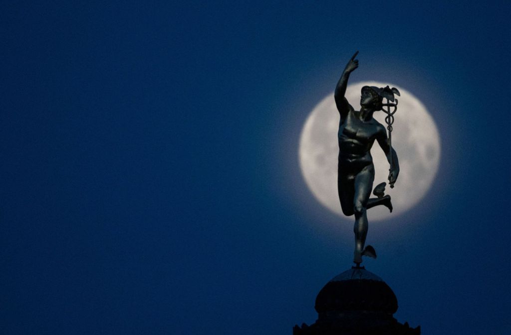 Die Merkurstatue des Bildhauers Ludwig von Hofer in Stuttgart zeichnet sich vor dem Mond ab.