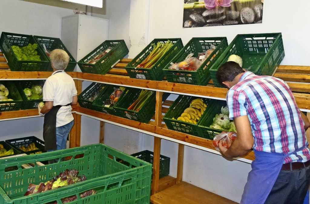 Mitarbeiter der Schwäbischen Tafel Möhringen füllen die Gemüsekisten im Laden auf. Foto: Theresa Ritzer