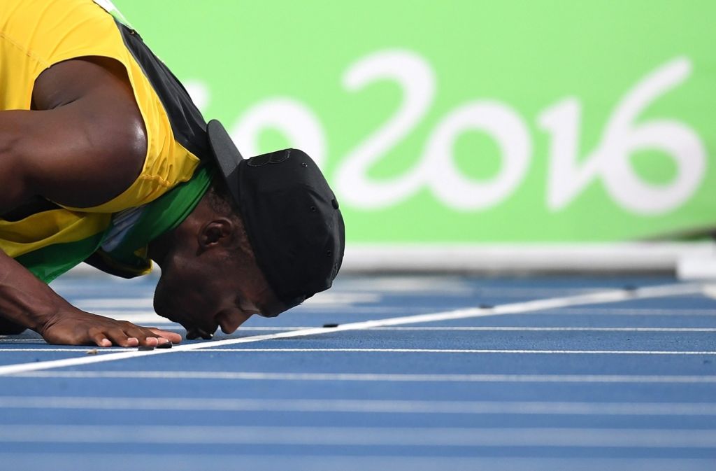 Mit einem Kuss des olympischen Bodens verabschiedet sich Starathlet Usain Bolt von seinen letzten Sommerspielen – im Gepäck hat er drei Goldmedaillen.