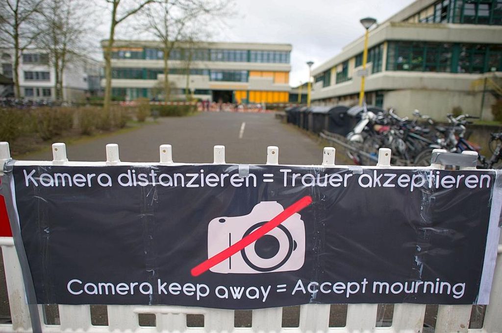 Ein Schild mit der Aufschrift "Kamera distanzieren = Trauer azeptieren" hängt vor dem Joseph-König-Gymnasium in Haltern.