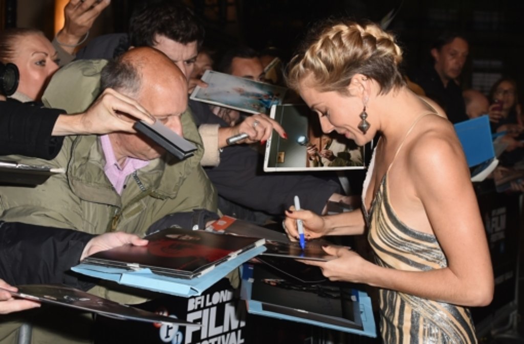 Sienna Miller schreibt bei der Premiere von "Foxcatcher" in London eiftig Autogramme.