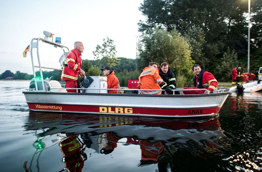 Feuerwehrleute und Helfer der DLRG sind auf dem Hohnsensee in Hildesheim (Niedersachsen) mit einem Boot unterwegs, das für den Transport von Sandsäcken und Arbeitsgeräten zur Deichsicherung eingesetzt wird.