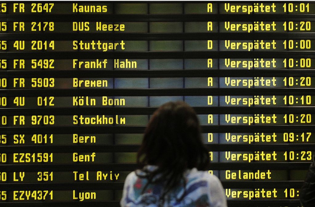 Eine Frau steht auf dem Flughafen Berlin-Schönefeld vor einer Anzeigetafel, auf der verspätete Flüge aufgelistet werden. Foto: Hannibal Hanschke/dpa