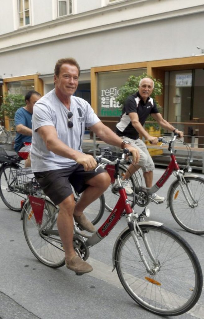 Schwarzenegger verlegt sich auf Vortragsreisen, zieht sich ansonsten aber stark aus der Öffentlichkeit zurück. Hier radelt er am 4. Juli 2012 durch Graz. In Richtung Hollywood hat er seine Fühler ganz sachte wieder ausgestreckt, gibt sich aber vorerst mit Nebenrollen zufrieden.
