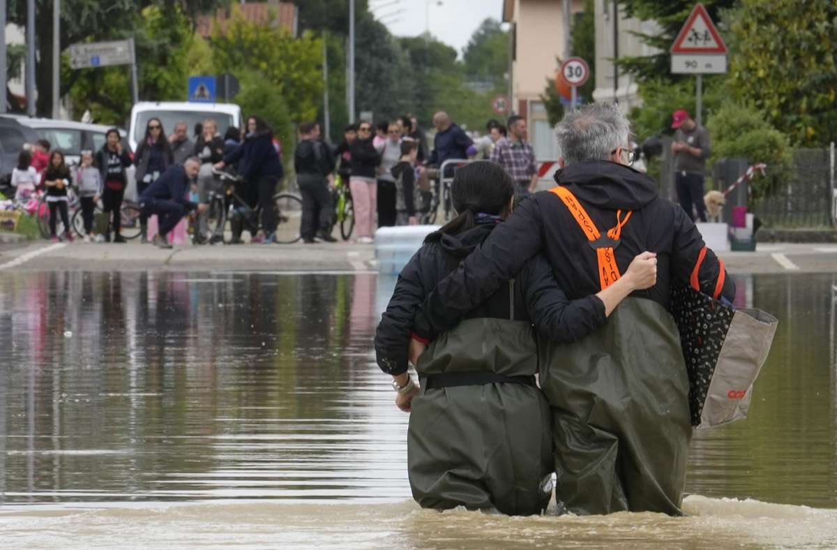 Lugo: Ein Paar geht auf einer überfluteten Straße.