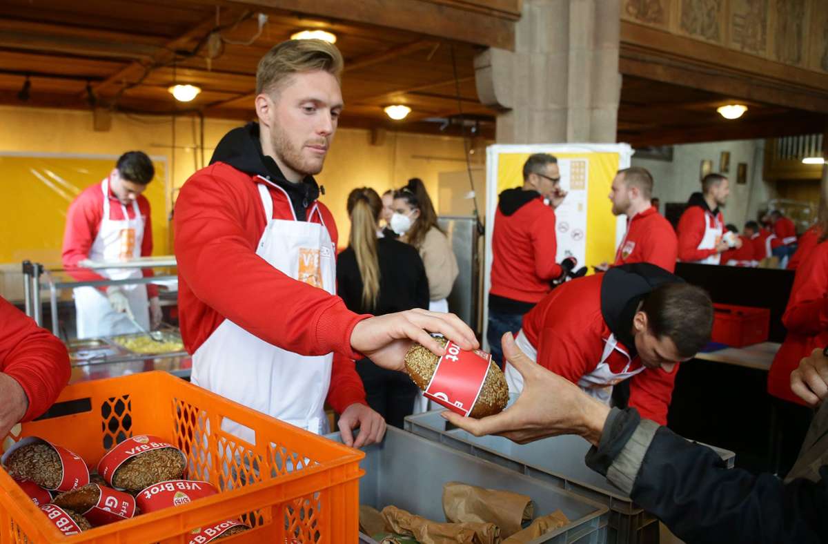 Florian Müller teilt ein VfB-Brot aus. Das Backerzeugnis ist für viele Bedürftige ein wichtiger Bestandteil ihres Speiseplans während der sieben Wochen andauernden Vesperkirche.