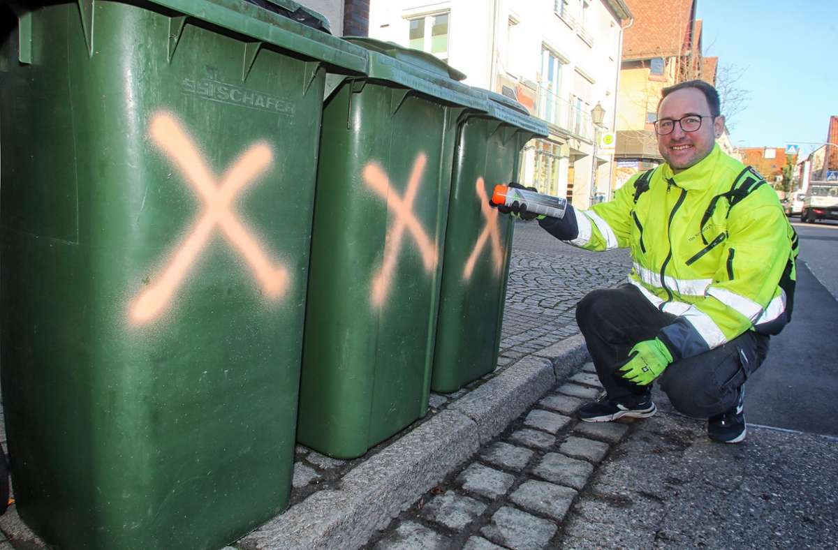Müll-Scout Tim Krawczyk markiert mit Kreidespray Papier-Tonnen, in die falscher Müll geworfen wurde.