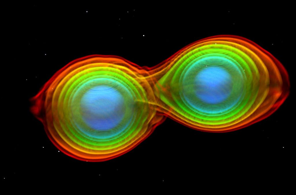 Höhere Dichte (das Innere der Neutronensterne) ist blau dargestellt, geringere Dichte (Hülle der Neutronensterne) ist rot dargestellt.