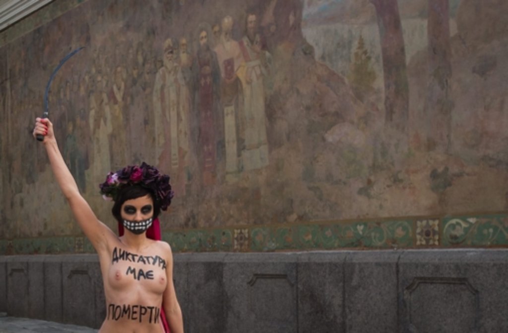 Trotz klirrender Kälte hat eine Femen-Aktivistin barbusig gegen Janukowitsch protestiert. „Tod der Diktatur“ stand auf ihrem Oberkörper.