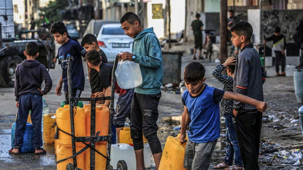 Kinder stehen in Rafah mit Kanistern Schlange, um sie mit Trinkwasser zu füllen.