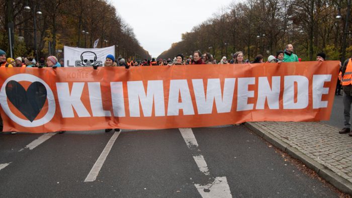 Klimaaktivist steigt auf Kran und entrollt Banner