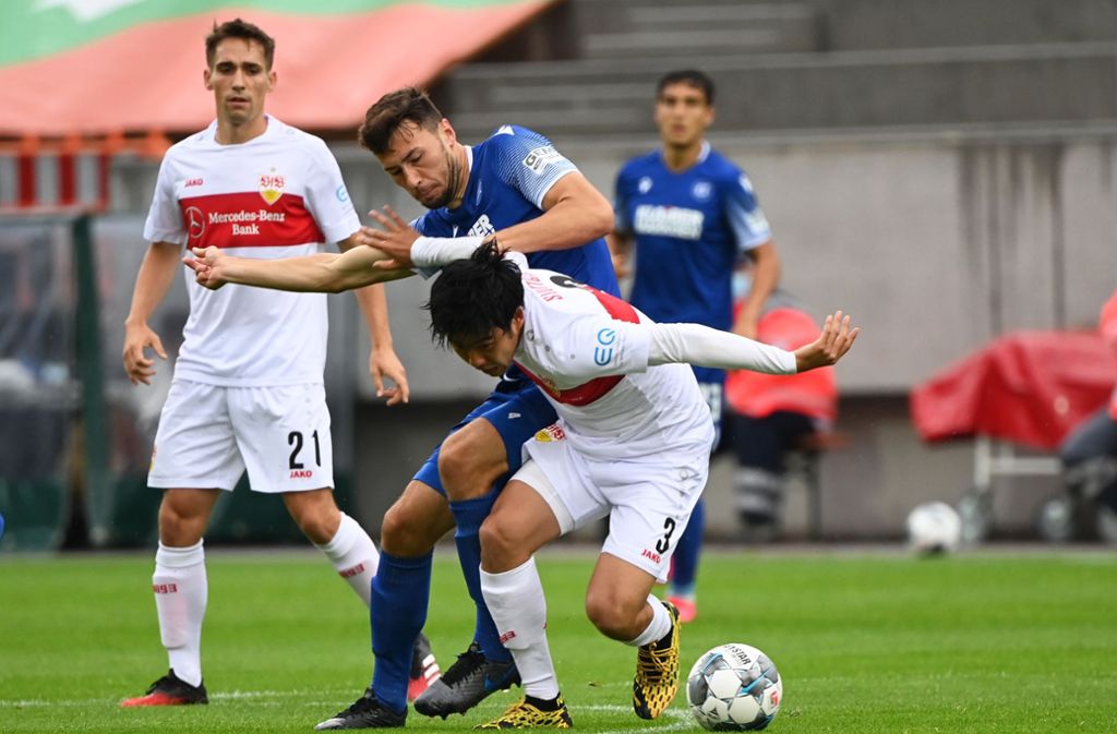 Karlsruhes Lukas Fröde und Stuttgarts Wataru Endo kämpfen um den Ball.
