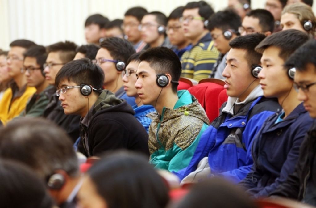 Die Studenten hörten die Übersetzung der Rede per Kopfhörer.