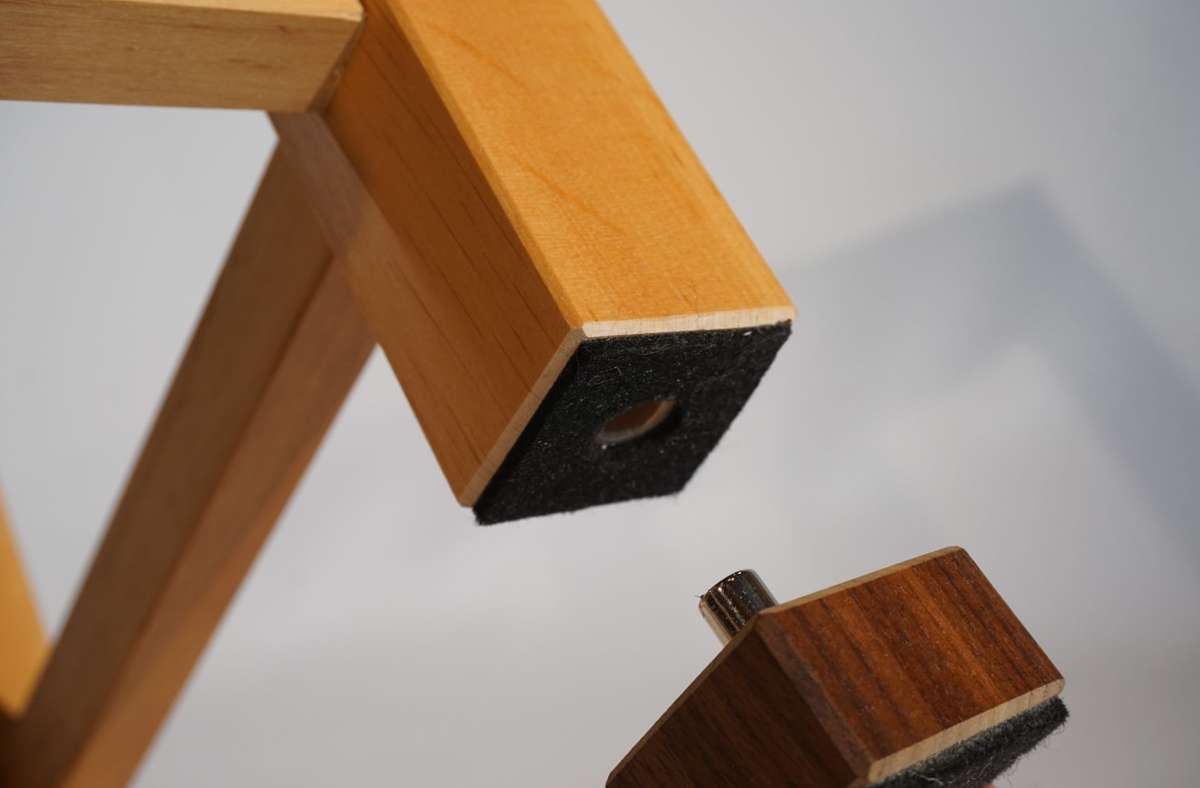 Der Holzwürfel mit Magnet kann leicht an dem den Stuhlbeinen oder ansonsten am Boden des Sitzes angebracht werden