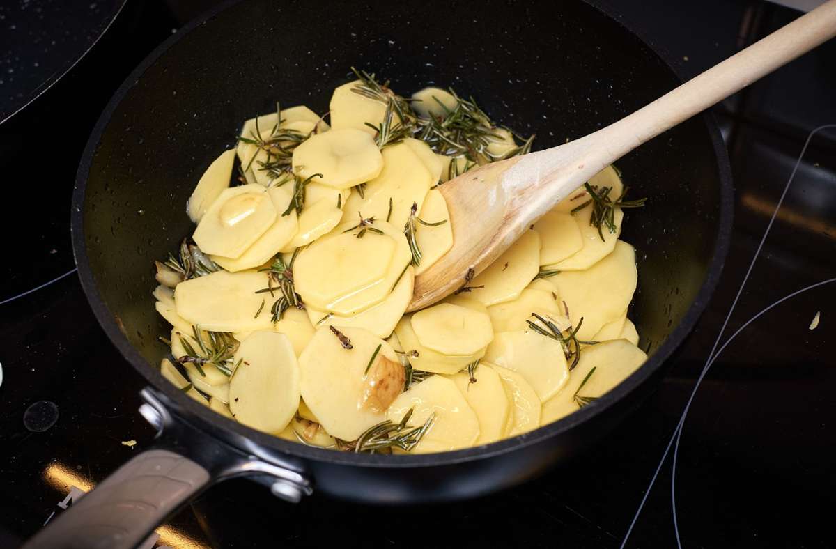 Die Kartoffeln waschen und in sehr dünne Scheiben schneiden oder hobeln. Die Kartoffeln zum Knoblauchöl in die Pfanne geben und 10 Minuten darin marinieren.
