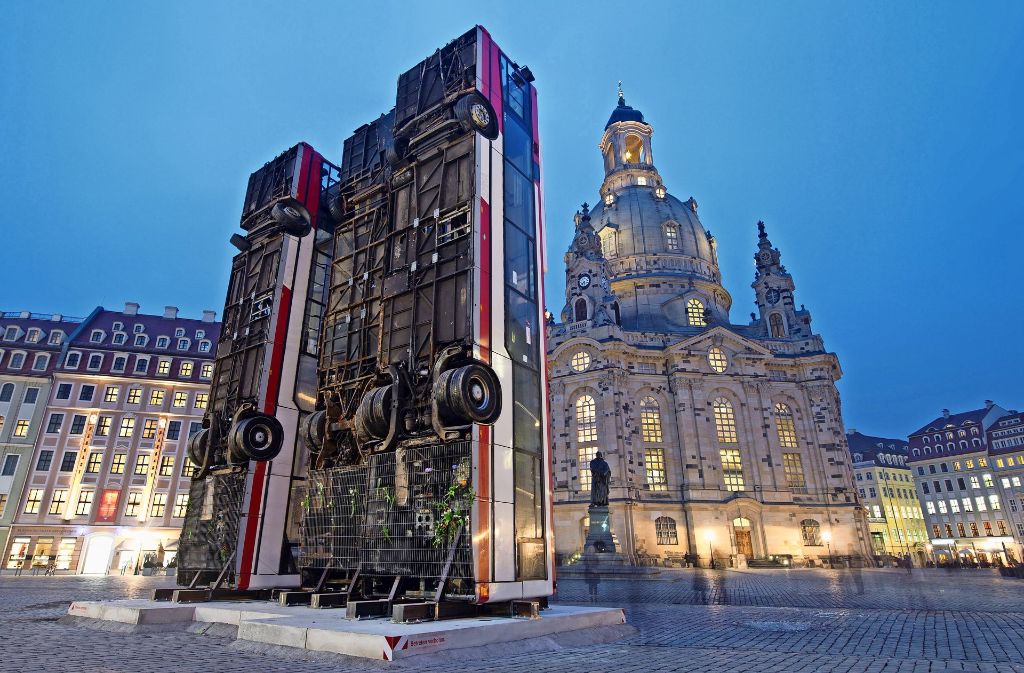 Umstrittenes Kunstwerk: Drei Busse stehen aufrecht vor der Dresdner Frauenkirche Foto: dpa