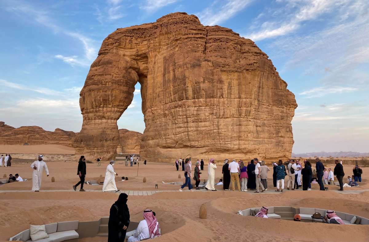 Männer und Frauen, Touristen und Einheimische genießen gemeinsam die Abendstimmung am Elefanten-Felsen im Norden Saudi-Arabiens.