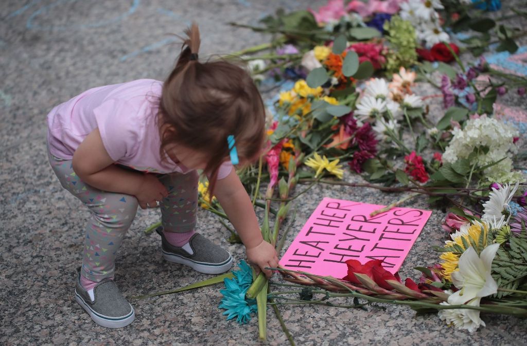 Ein kleines Mädchen legt Blumen in Chicago in Gedenken an Heather Heyer nieder. Heyer war am Wochenende in Charlottesville getötet worden, als ein 20-Jähriger mit dem Auto in eine friedlich protestierende Menschenmenge gegen die Ultrarechten raste.