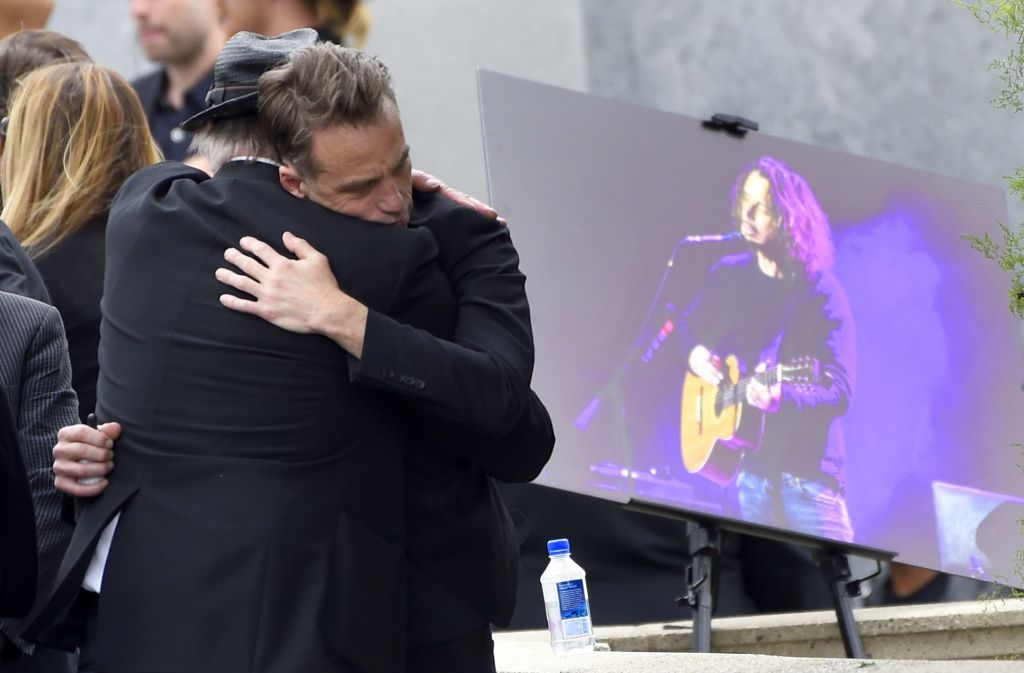 Matt Cameron (rechts) von „Soundgarden“ umarmt während der Beerdigung einen Gast.