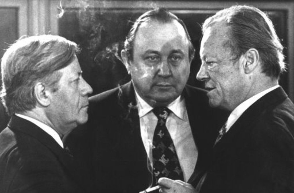 Nachdem er 1962 zum Innensenator ernannt worden war, holt Willy Brandt (rechts, in der Mitte Hans-Dietrich Genscher) Schmidt 1964 in seine zehnköpfige Regierungsmannschaft für die Bundestagswahlen 1965. Bis zum Jahr 1987 wird er Mitglied des Hohen Hauses bleiben.