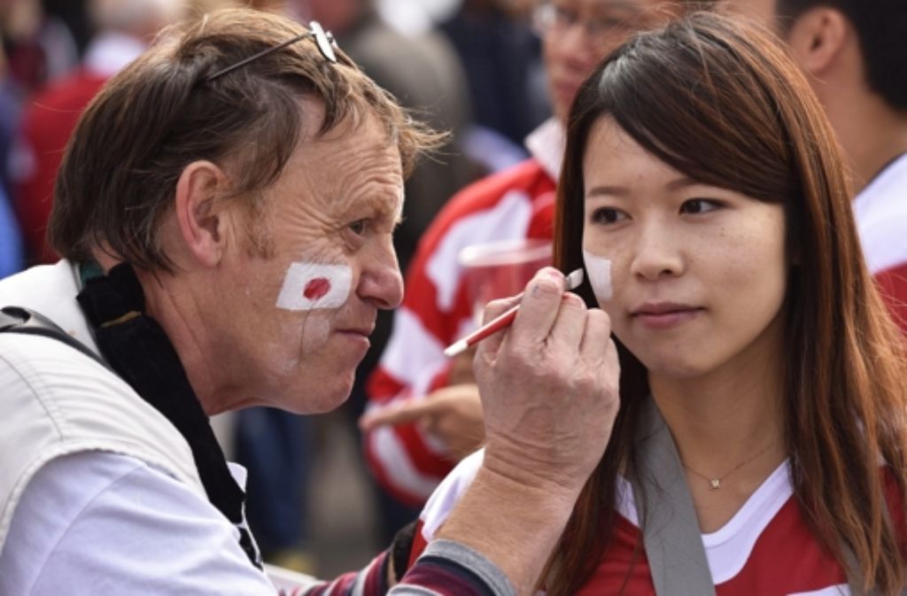 Die japanischen Fans bemalen sich vor dem Spiel