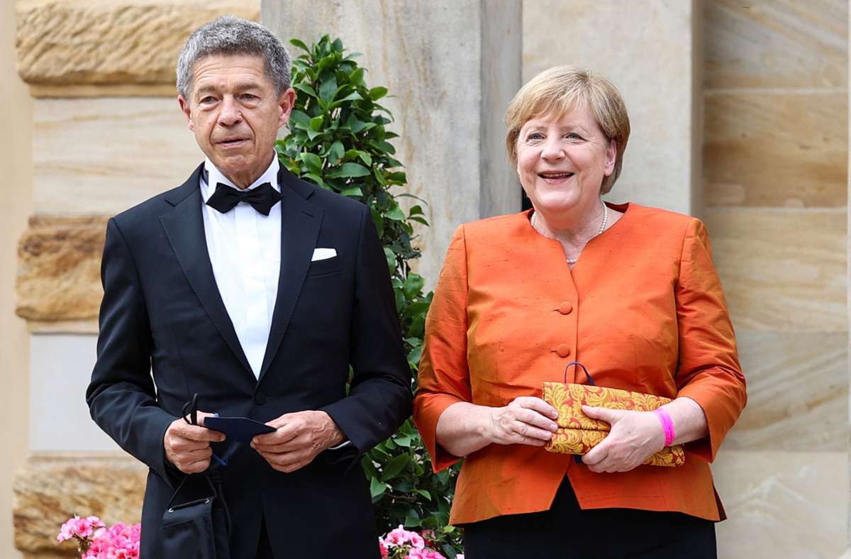 Ganz in orange: Angela Merkel und ihr Mann Joachim Sauer bei den Bayreuther Festspielen. Foto: dpa/Daniel Karmann