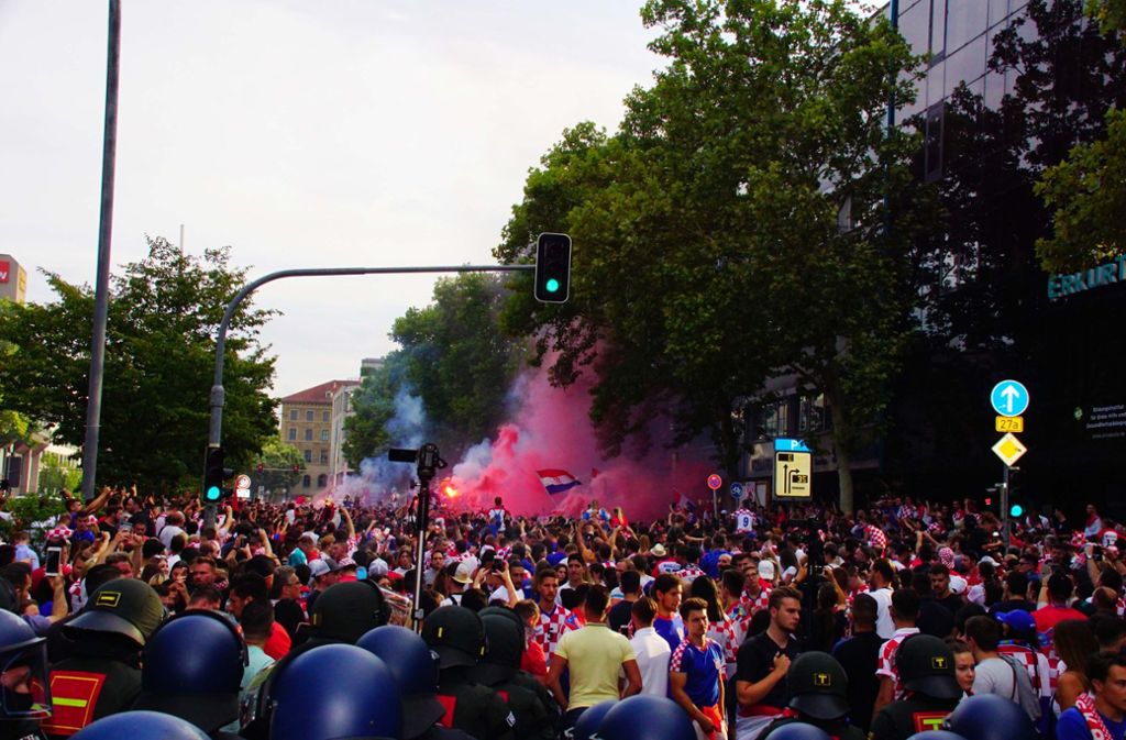 Einige Fans auf der Theodor-Heuss-Straße werfen immer wieder Böller in die Menge und auf Polizisten.