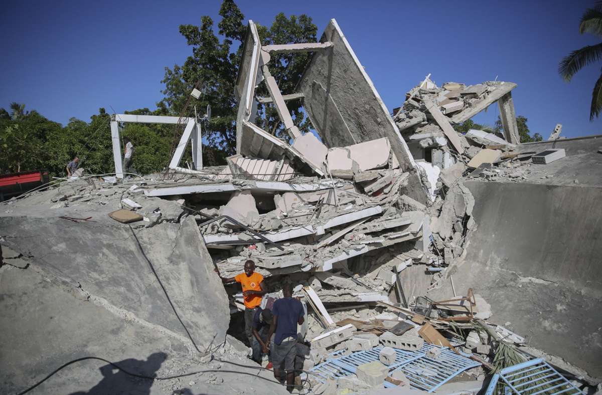 Menschen suchen nach dem Erdbeben  nach Überlebenden in einem zerstörten Haus. Foto: dpa/Joseph Odelyn