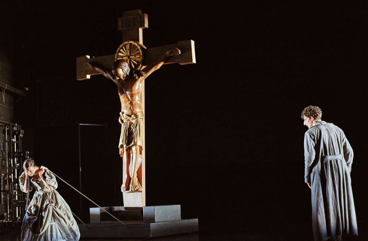 Sofia (Paula Skorupa) hält fest an ihrem Glauben und zieht unermüdlich eine Jesusfigur hinter sich her. Raskolnikow (David Müller) glaubt nicht an Gott angesichts so vielen Leids in der Welt. Szene aus Dostojewskis „Schuld und Sühne“.