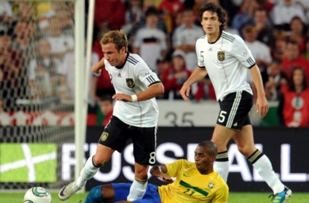 ermanys Mario Götze (L) and Brazils Fernadinho (C) fight for the ball during their international friendly soccer match Germany vs Brazil at Mercedes-Benz Arena in Stuttgart, Germany, 10 August 2011.