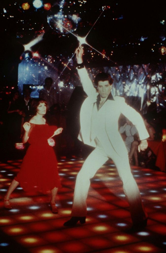 1977: Mit feschem Disco-Look und Föhnwelle in dem Tanzfilm „Saturday Night Fever“. John Travolta spielt darin den Italoamerikaner Tony Manero, der in einem Farbengeschäft angestellt ist. Seine Leidenschaft gilt aber der Diskothek 2001 Odyssey in New York.
