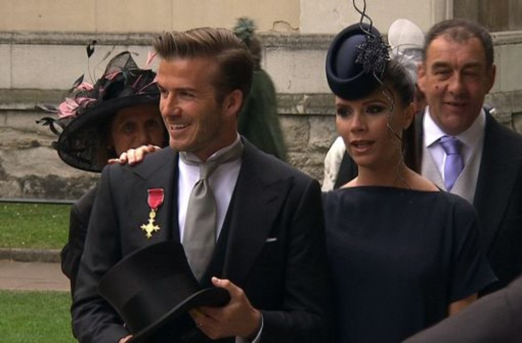David und Victoria Beckham bei ihrer Ankunft. Er trägt Frack, sie Faszinator, jenes winzige Hütchen, das sich immens in die Höhe zwirbelt.