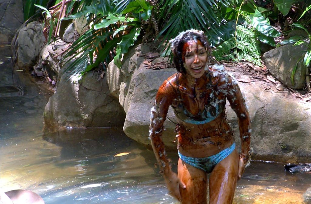 Geteert und gefedert kehrt Gisele Oppermann nach ihrer erfolgreichen Dschungelprüfung stolz ins Camp zurück und wäscht sich anschließend im Teich.