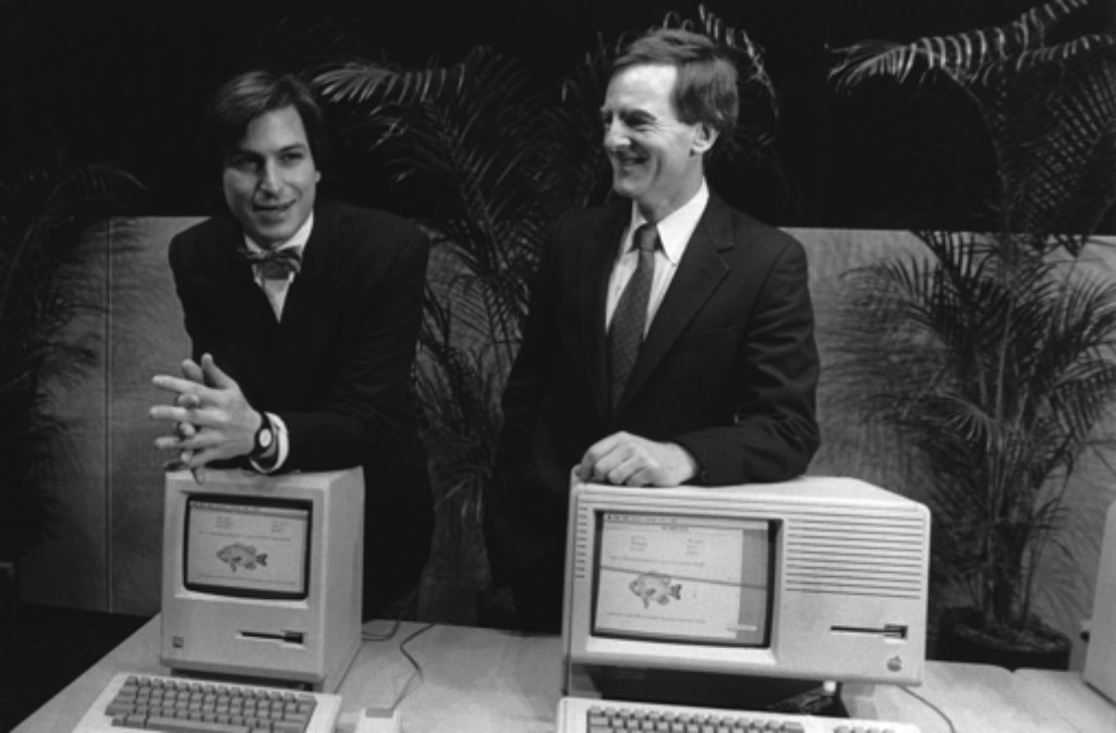 1984 stellt Apple den ersten Macintosh vor - seine Väter sind Steve Jobs (links, mit Marketing-Chef John Sculley) und Steve Wozniak.