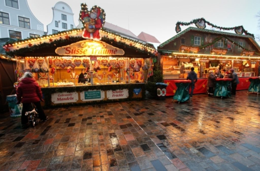 Auf dem Weihnachtsmarkt in Rostock (Mecklenburg-Vorpommern) sind bei nasskaltem Wetter nicht viele Besucher unterwegs.