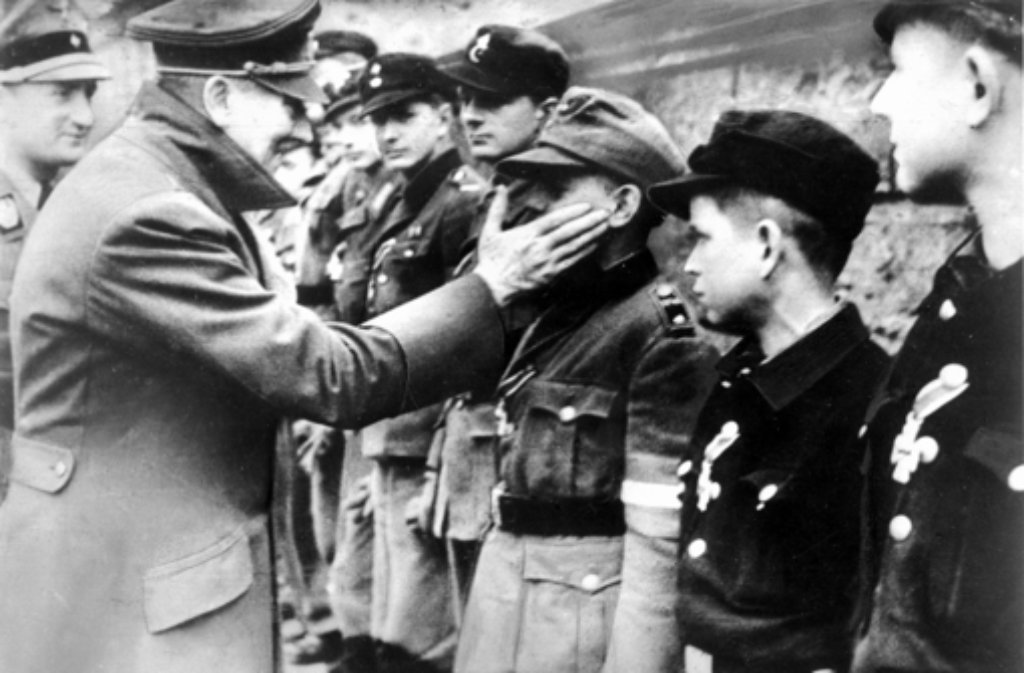 Eine der letzten Aufnahmen von Adolf Hitler vom 20. April 1945, seinem Geburtstag, zeigt ihn bei der Auszeichnung von Mitgliedern der Berliner Hitler-Jugend, die zum Ende des Zweiten Weltkrieges in Volkssturmeinheiten zusammengefaßt wurden.