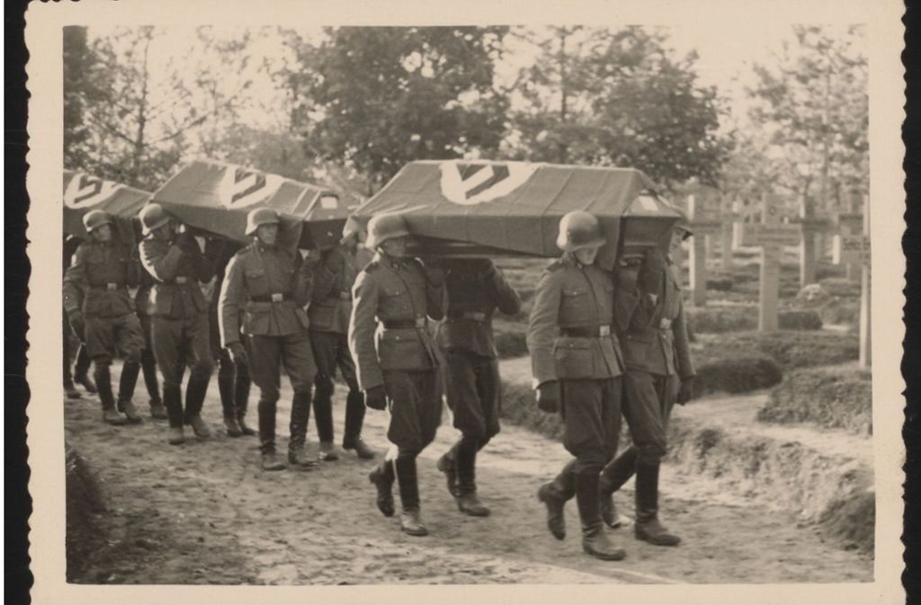 Vermutlich in Chelm stationierte SS-Soldaten tragen die Särge der beim Aufstand getöteten Deutschen zum Gräberfeld.