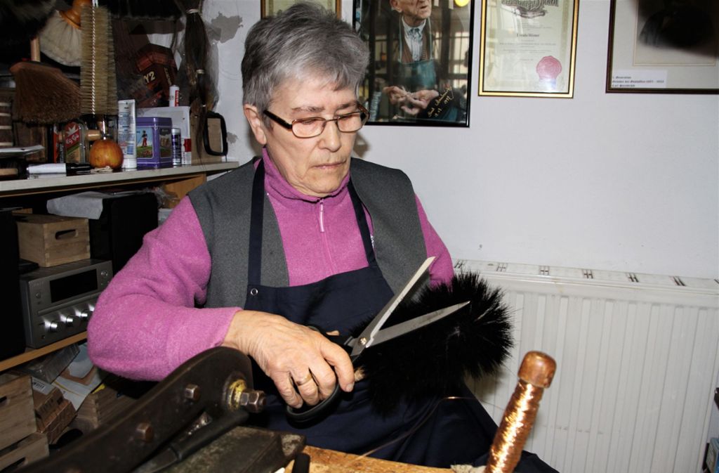 Ursula Römer bei der Herstellung eines Besens in ihrer winzigen Werkstatt. Da muss sie manchmal auch ein bisschen Coiffeur sein und die Haare in Form schneiden.