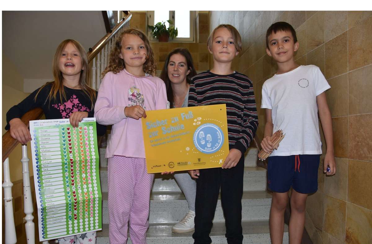 Schülerinnen und Schüler der Klasse 2 A der Wilhelmsschule Wangen und ihre Lehrerin zeigen am Pyjama-Tag ihr Schulwegplakat und die Auszeichnung. Foto: /Mathias Kuhn
