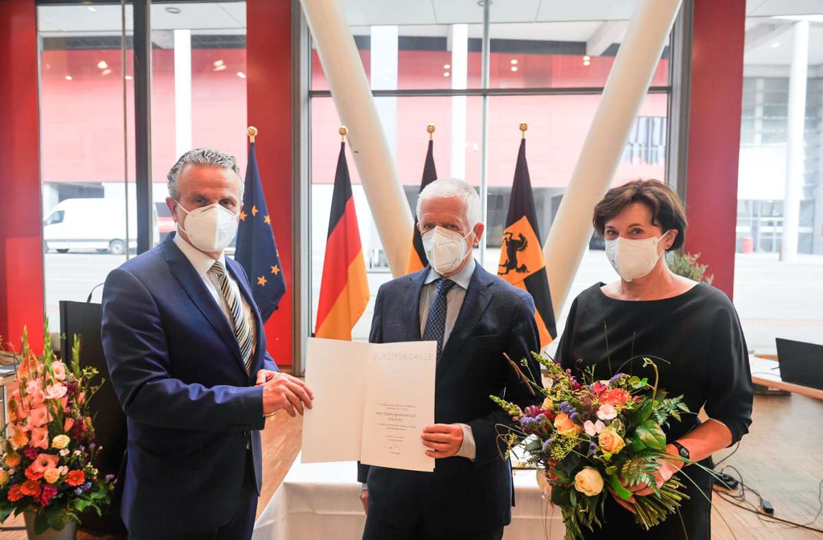 Fritz Kuhn (Mitte) bekommt die Urkunde zur Bürgermedaille, seine Frau Waltraud Ulshöfer hat Blumen bekommen.