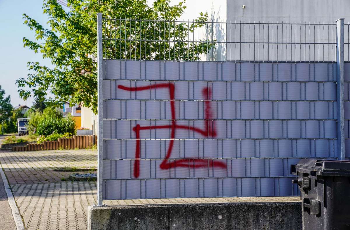 Die Symbole sind in roter Farbe an einem Zaun, Hausfassaden und Gehwegen angebracht worden.