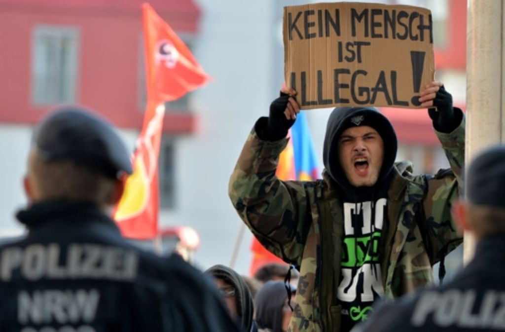 Linke und rechte Demonstranten stehen sich in Köln gegenüber.