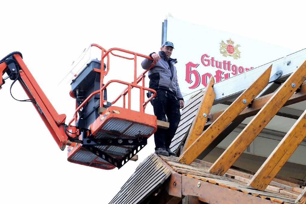 Ein Kran hebt den Arbeiter auf das Dach des Grandls Höfbrauzelts.