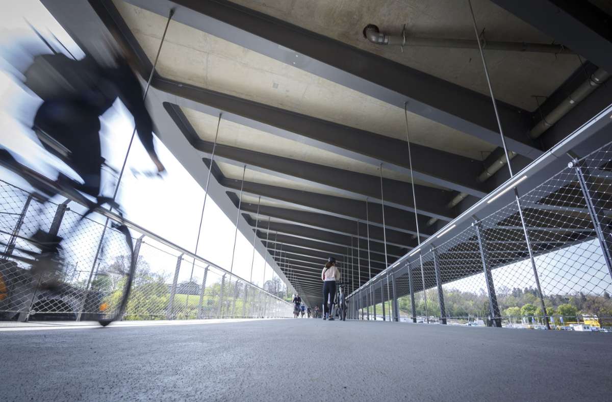 Die Ingenieure haben den Fußgänger- und Radüberweg per Edelstahlzugstangen unter die Eisenbahnbrücke gehängt. So können die Passanten wettergeschützt den Neckar überqueren.