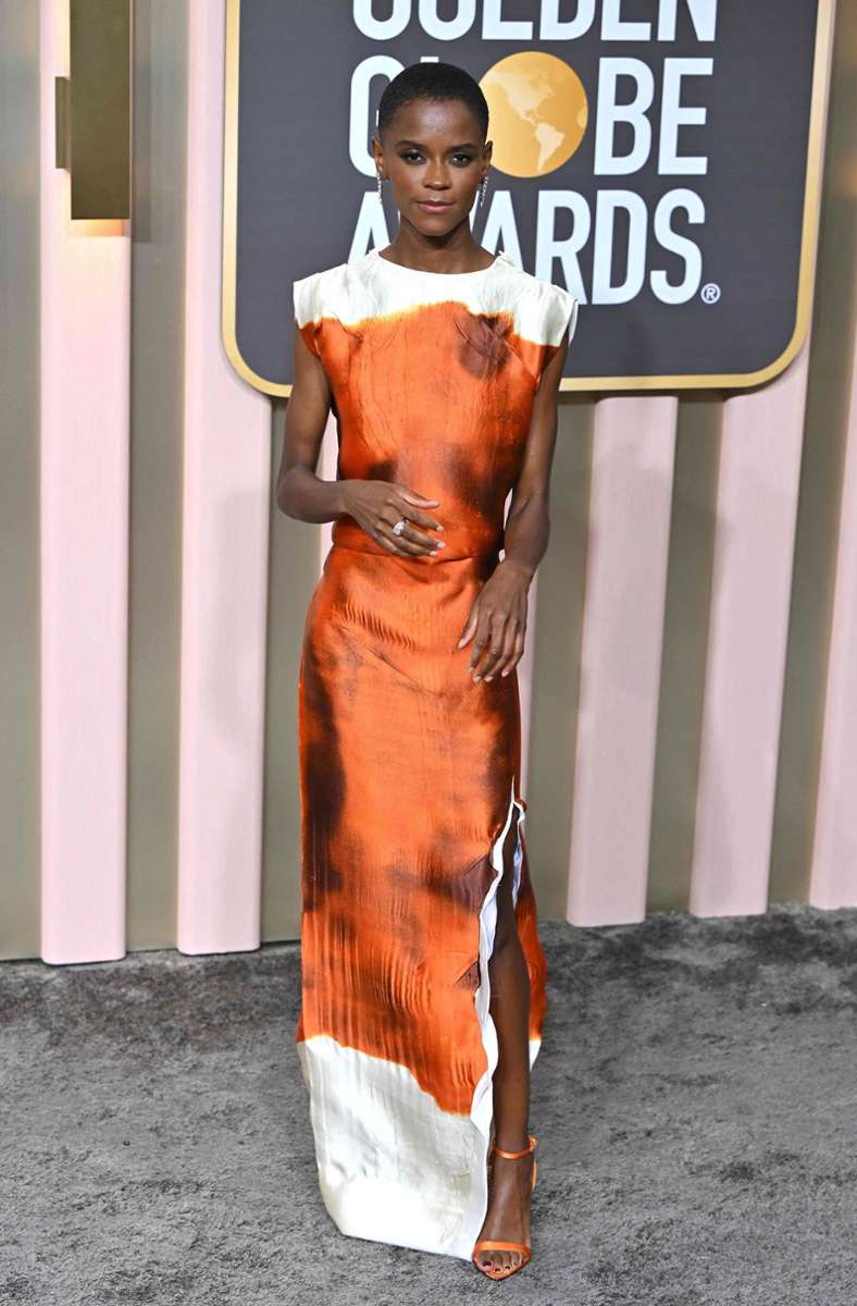 Hui! Da gibt es einfach nichts zu meckern – „Black Panther“-Star Letitia Wright macht mit diesem schlichten Prada-Seidenkleid in Orange bis Kupfer alles richtig.