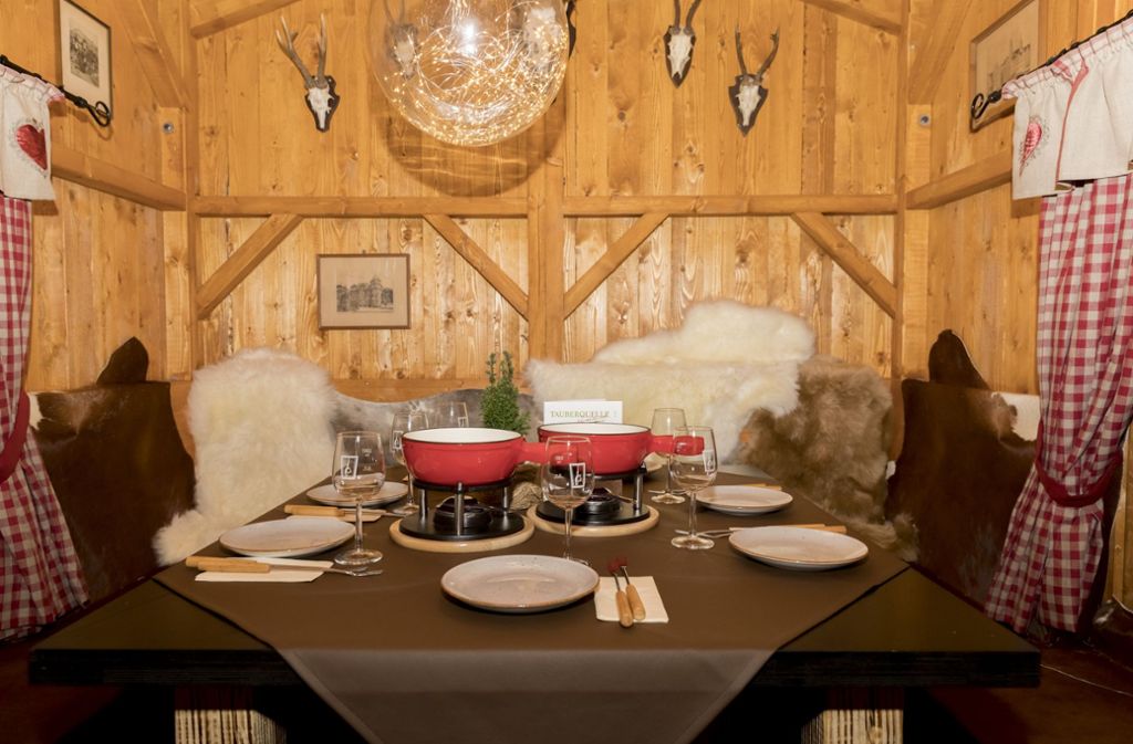 In Frank Schäfers Weihnachtshütte sitzen gut 20 Gäste wie in einer Mini-Ski-Alm beim Käsefondue.